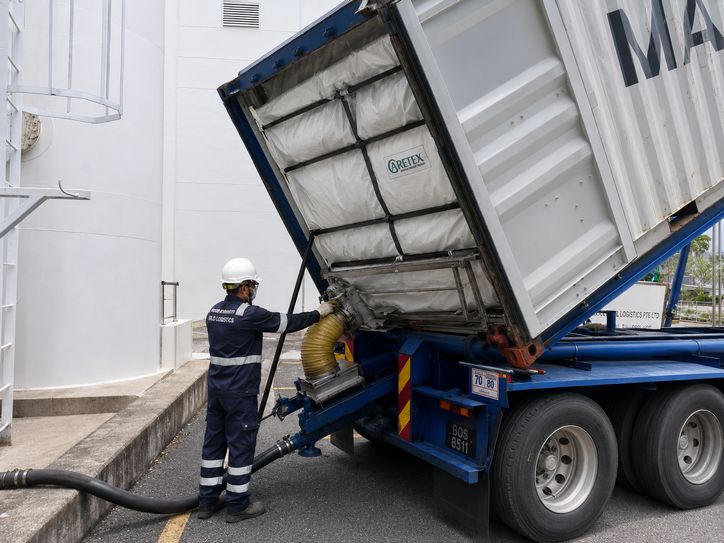 Operator monitoring dry bulk transfer from tipped container